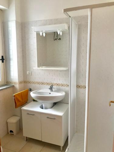 a white bathroom with a sink and a shower at San Rocco one bed Apartments 4A1 9 in Isca sullo Ionio