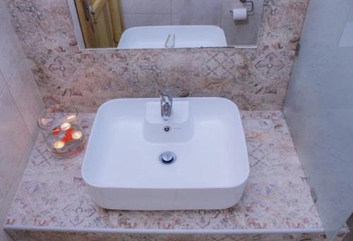 uma casa de banho com um lavatório branco e um espelho. em Villa Limnioni em Archangelos