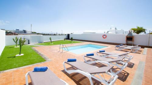 un patio avec des chaises et une piscine sur le toit dans l'établissement Blancazul Brisa Marina, à Yaiza