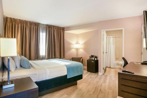 a hotel room with a bed and a bathroom at Safari Inn, a Coast Hotel in Burbank