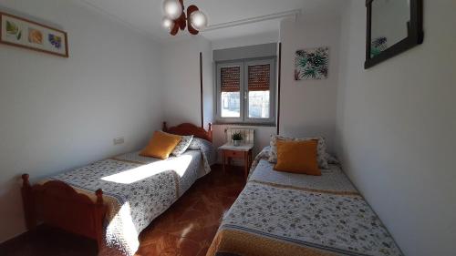 a small room with two beds and a window at CASA LA REVERENDA in Barcia