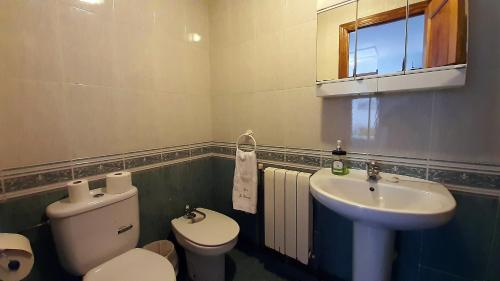 a bathroom with a toilet and a sink at CASA LA REVERENDA in Barcia
