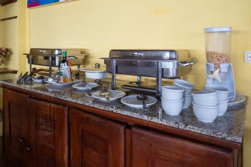 eine Küchentheke mit Töpfen und Pfannen darauf in der Unterkunft Pousada Villa do Sol in Genipabu