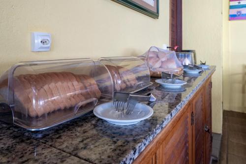ein Buffet mit Schalen und Tellern auf der Theke in der Unterkunft Pousada Villa do Sol in Genipabu