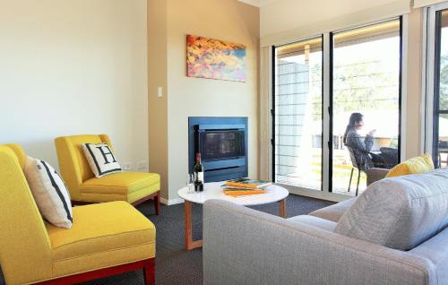 a living room with a couch and chairs and a fireplace at H Boutique Hotel in Pokolbin