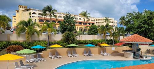 a resort with a pool and chairs and umbrellas at Park Royal Homestay Club Cala Puerto Rico in Humacao