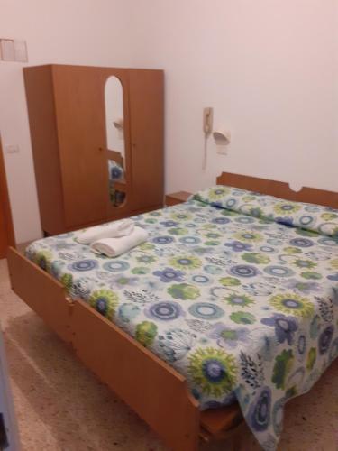 里米尼的住宿－HOTEL ROSSINI，一间卧室配有一张带花卉棉被的床