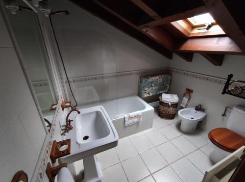 a bathroom with a tub and a sink and a toilet at Asturias Apartamentos Rurales Naveces in Naveces