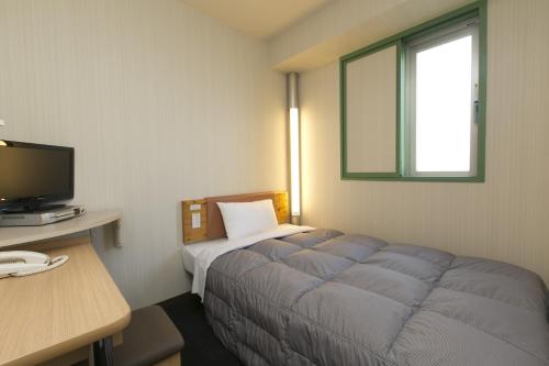 a room with a bed and a desk and a television at R&B Hotel Nagoya Nishiki - Vacation STAY 37479v in Nagoya