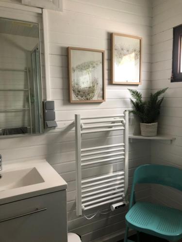 a bathroom with a sink and a mirror and a chair at Chalet Happiness in Zutendaal