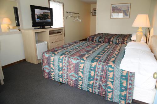 a hotel room with a bed and a flat screen tv at Starlite Motel in Wisconsin Dells