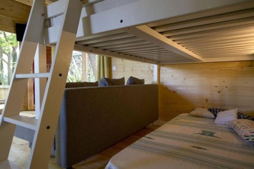 Zimmer mit Etagenbett und Sofa in der Unterkunft Les Moreres in Gandía