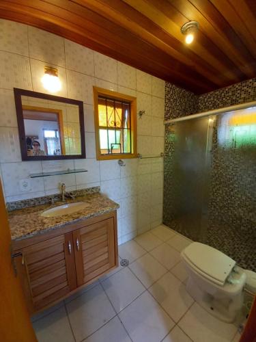 a bathroom with a toilet and a shower and a sink at Claire Cottage in Monte Verde