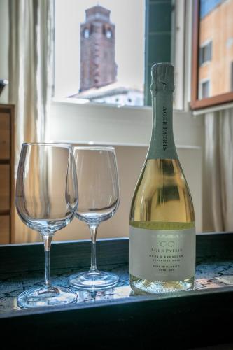 a bottle of wine and two wine glasses on a counter at Infinite House Guglie in Venice