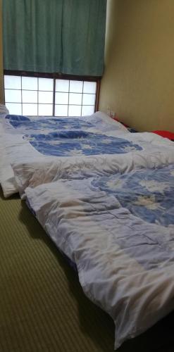 un letto non rifatto in una camera da letto con finestra di Suijin Hotel - Vacation STAY 38314v a Chichibu