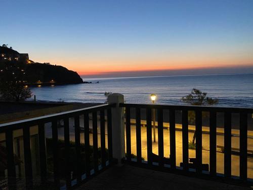 a view of the ocean at sunset from a balcony at Hotel Arimune in Bakio