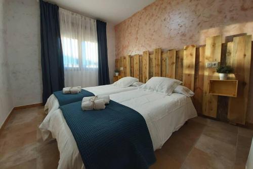 een slaapkamer met een groot bed en 2 handdoeken bij La Morada de los Olmos in Segovia