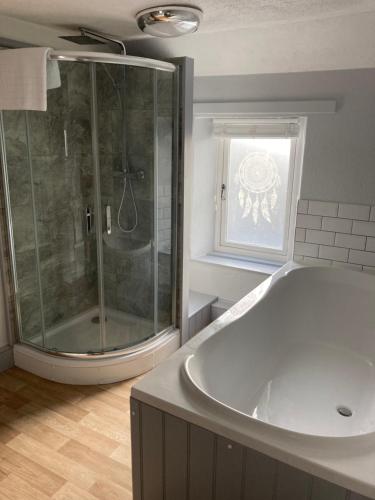 bagno con ampia vasca e doccia di Hunters Lodge Inn a Totnes