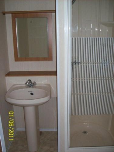a small bathroom with a sink and a shower at Domek Holenderski Jasieniec in Żabinki