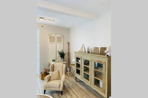 a living room with a cabinet and a chair at Cosy house in a charming village in Beauvechain