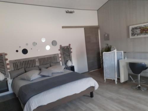 une chambre avec un grand lit et un bureau dans l'établissement Belle de nuit, à Le Trait dʼUnion
