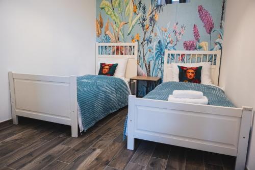 a bedroom with two twin beds and a mural at 'tBegijnhof in Ghent