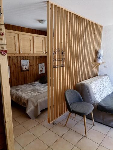 une chambre avec un lit et une chaise dedans dans l'établissement cimes d'or, aux Contamines-Montjoie