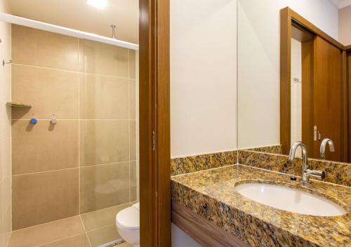 uma casa de banho com um lavatório, um chuveiro e um WC. em Ondas Praia Resort All Inclusive em Porto Seguro
