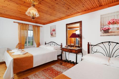 a bedroom with two beds and a table and a mirror at Villa Nicole in Theológos