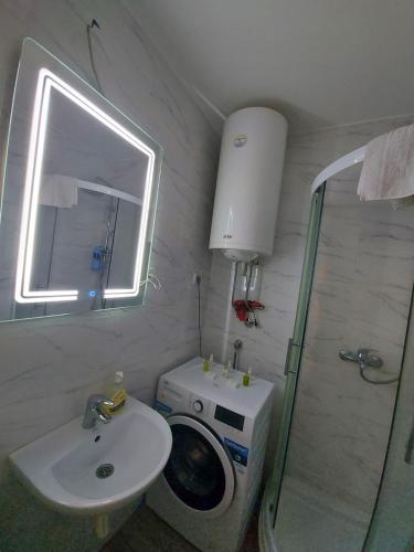 a bathroom with a sink and a washing machine at Studio IKA Belgrade Airport Free Parking possible Self Check-In Terrace in Ledine