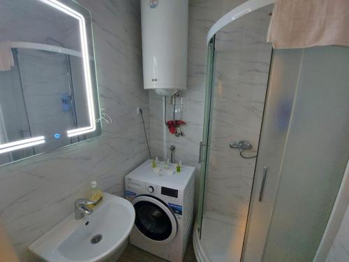 a bathroom with a shower and a washing machine at Studio IKA Belgrade Airport Free Parking possible Self Check-In Terrace in Ledine