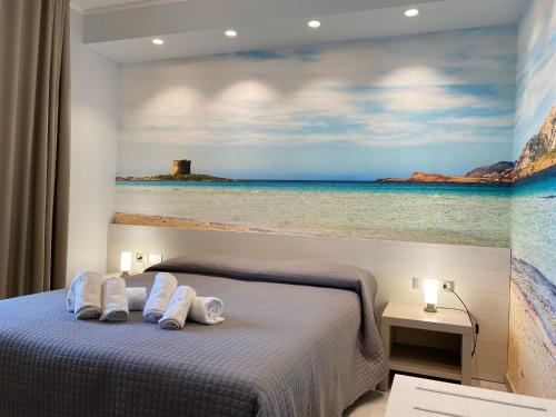 Un dormitorio con una pintura del océano y una cama en 103 Boutique Hotel Stintino, en Stintino
