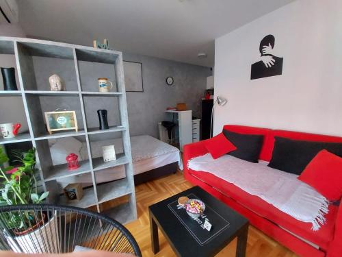 - un salon avec un canapé rouge et une étagère dans l'établissement Studio IKA, à Ledine