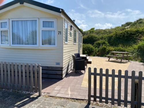 a small house with a fence in front of it at Chalet Playa direct aan zee in IJmuiden in IJmuiden