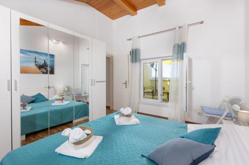 a bedroom with two beds with towels and a mirror at The Rooftop Apartment Punat in Punat