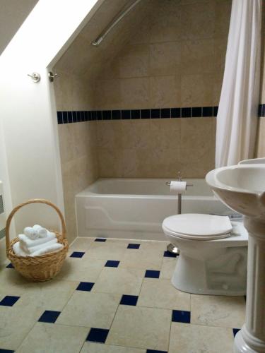 a bathroom with a toilet and a tub and a sink at Au Cachalot Caché le gîte hôtel in Tadoussac