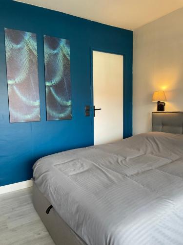 - une chambre avec des murs bleus et un lit avec deux photos dans l'établissement Studio Terrasse Vue Mer, à Villers-sur-Mer