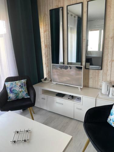 un salon avec une télévision sur un meuble blanc dans l'établissement Studio Terrasse Vue Mer, à Villers-sur-Mer