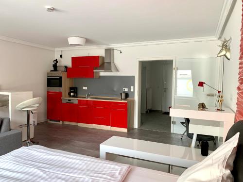 eine Küche und ein Wohnzimmer mit roten Schränken in der Unterkunft Apartment Martinstraße 7b in Hannover