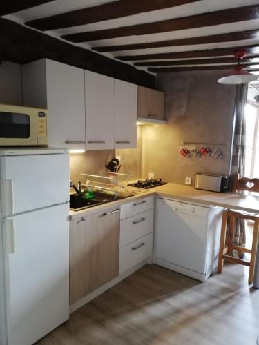 a kitchen with white cabinets and a white refrigerator at Maison de l'Epine -spa- Versant du soleil in Granier