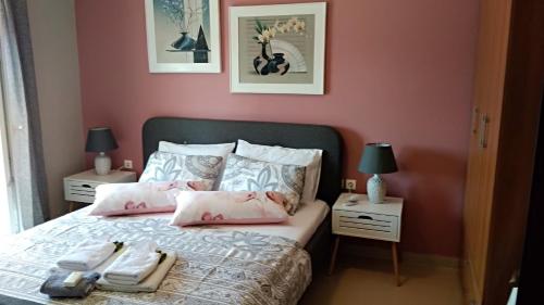 a bedroom with a bed with pink walls at Iris Deluxe Suites 2 in Kavála