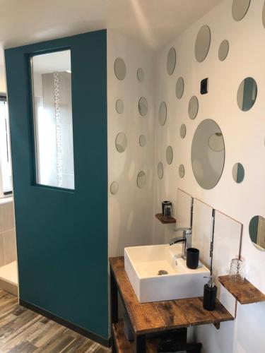 a bathroom with a white sink and a green door at Au pied de la dune in Sangatte