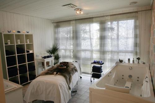 a bathroom with a bed and a bath tub at Orbaden Spa & Resort in Vallsta