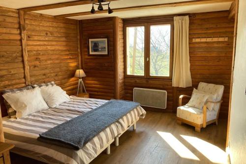 una camera con un letto e una sedia e una finestra di Paisible chalet montagne avec option jacuzzi a Séez