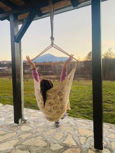 a girl is swinging in a hammock at Rtanjska bajka in Boljevac
