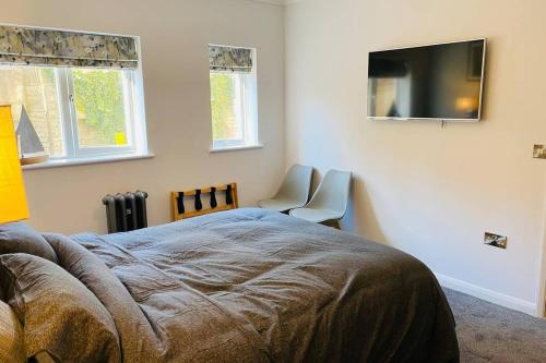a bedroom with a bed and a flat screen tv at Luxury Apartment-Golden Triangle, Parking & Garden in Norwich