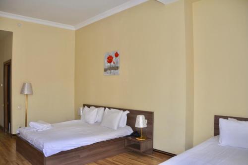 a hotel room with two beds with white sheets at Boutique Hotel O. Galogre in Batumi