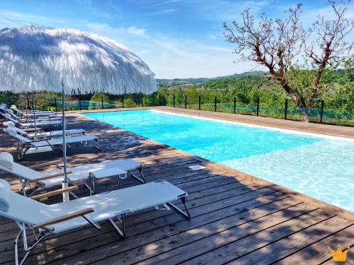 - une piscine avec des chaises longues et un parasol dans l'établissement Estafête, à Sarrazac