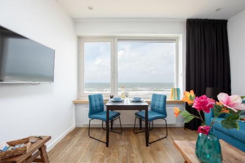 een eetkamer met een tafel en stoelen en een raam bij Costa in Zandvoort