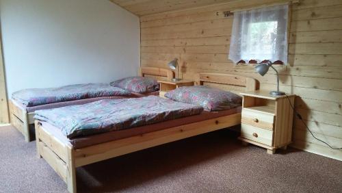 a bedroom with two beds and a lamp and a window at Autocamp Skalice in Slapy